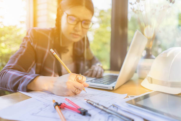 istock Architect women working on blueprint. Architects workplace - architectural project, blueprints, ruler, calculator, laptop and divider compass. Construction concept. Engineering tools,selective focus 1148856007