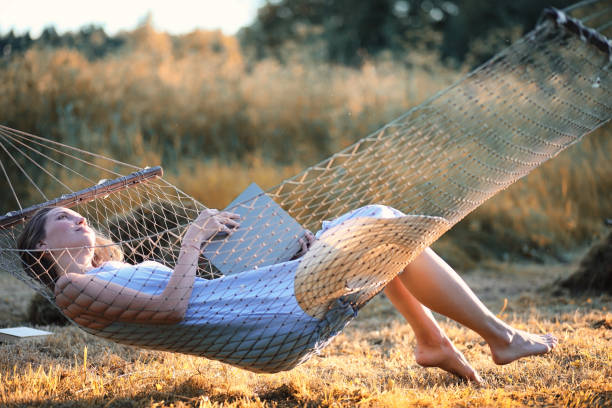 istock Beautiful girl in hammock reading a book 1148856905