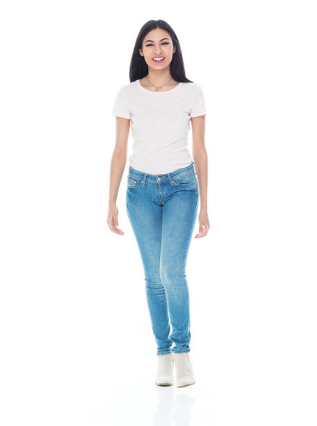 pretty latino female wearing tshirt and jeans - walking - arms at side imagens e fotografias de stock