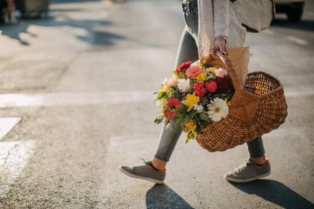 istock Young walking city streets with flower bouquet 1148859135