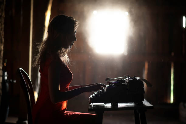 istock A girl in retro style prints on an old typewriter 1148859549