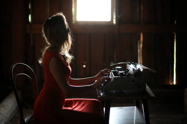 istock A girl in retro style prints on an old typewriter 1148859627