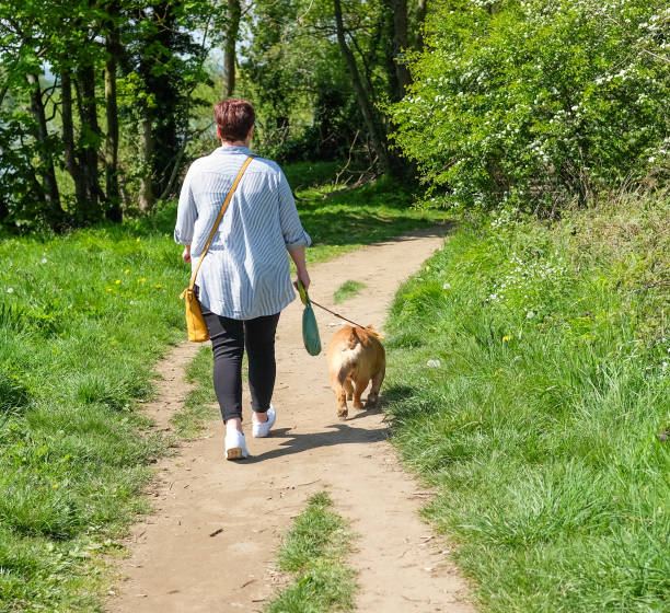 istock Woman out in Nature Walking her Dog 1148861907