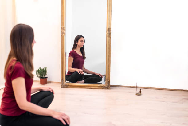 istock Woman meditating next to a mirror in a studio 1148864150