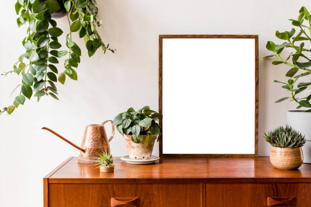 istock Nice and retro space of home interior with mock up poster frame, vintage cupboard with elegant floral accessories, a lot of plants in stylish pots. Cozy home decor. Minimalistic concept. Home garden 1148867286