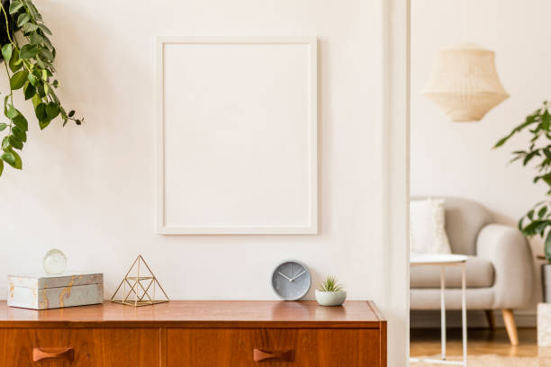 istock Stylish and retro space of home interior with white mock up frame, design sofa, furnitures, vintage cupboard with elegant accessories, plants and coffe table. Cozy home decor. Minimalistic concept. 1148868340