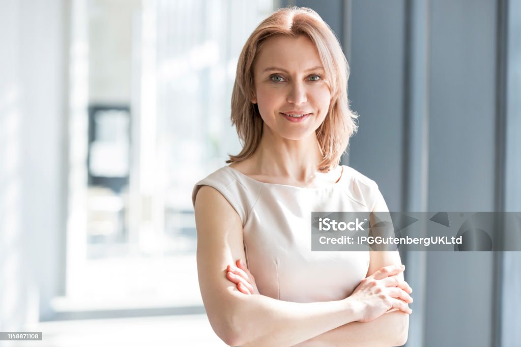 Porträt der schönen Geschäftsfrau steht mit Waffen im Büro gekreuzt - Lizenzfrei Eine Frau allein Stock-Foto