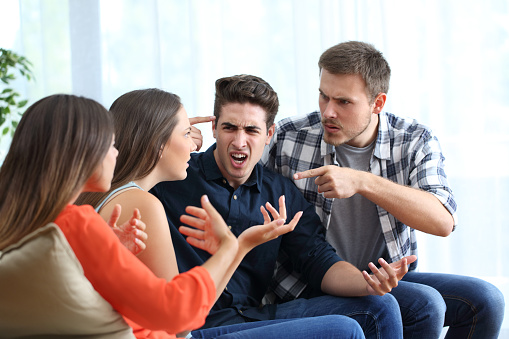 Cuatro amigos furiosos discutiendo en casa photo