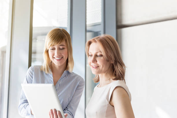 istock Professionals discussing over digital tablet in office corridor 1148873975