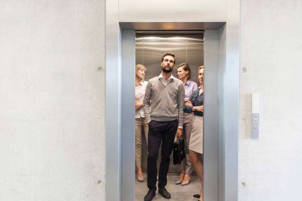 Confident business people standing in elevator at office