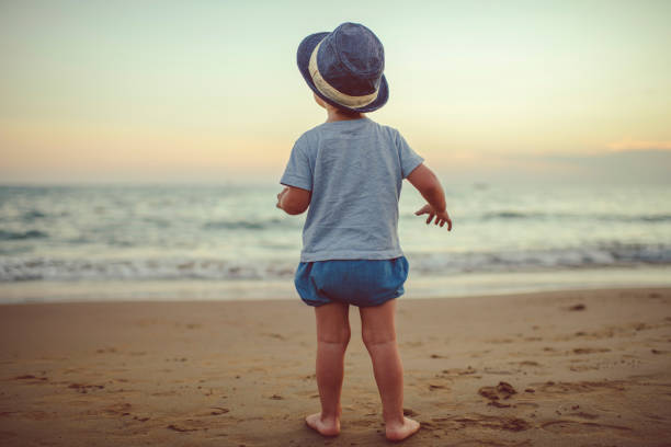 Happy child enjoying sunset near the sea
