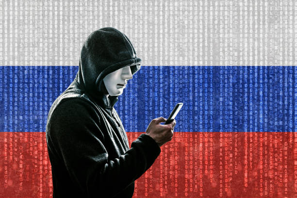 istock Russian hooded hacker with mask holding smartphone 1148875996