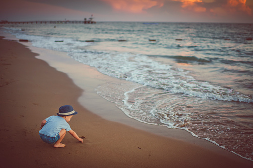 Happy child enjoying sunset near the sea