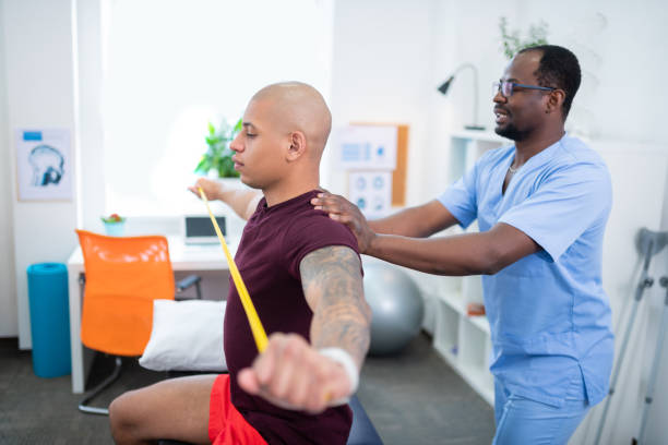 istock Sportsman doing exercises for back sitting near therapist 1148876359