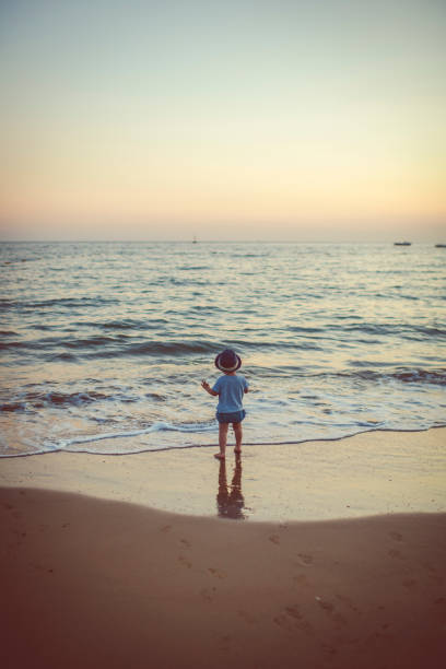 Happy child enjoying sunset near the sea