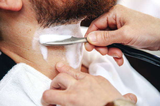 istock A barber shaves his client's beard in the traditional way. 1148879146