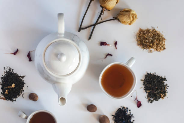 istock Tea set with white ceramic tea pot, dried rose flowers and other tea ingredients on the white. Flat lay view of various dried teas and teapot. View from above. Space for your text 1148880185