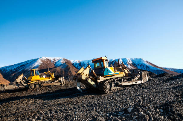 istock Bulldozers rake mountain earth in heaps 1148880251