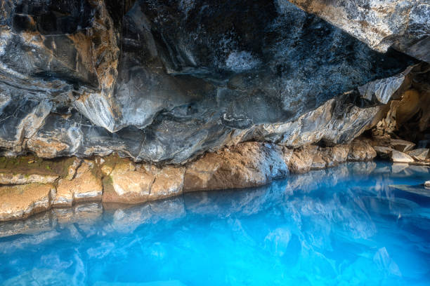 Grjotagja cave in Iceland with thermal spring hot amazing blue water, small lava cave Grjotagja cave in Iceland with thermal spring hot amazing blue water, small lava cave near lake Myvatn grjótagjá thermal spring stock pictures, royalty-free photos & images