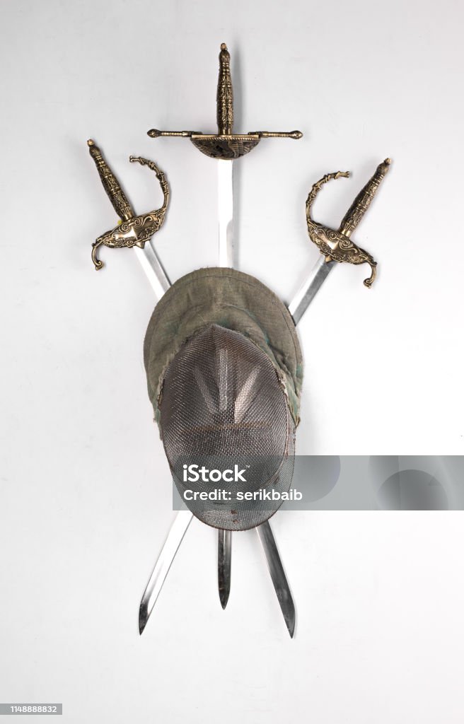 fencing helmet and sword, saber, rapier isolated on a white background Ancient Stock Photo