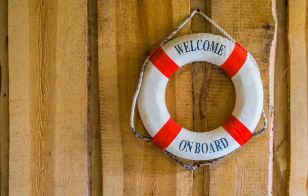 life buoy with the text welcome on board, nautical and travel background