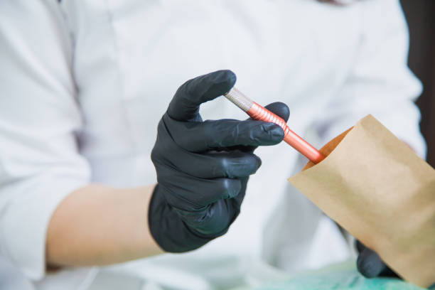 istock Cosmetologist put tattoo pen in craft package for sterilization 1148892805