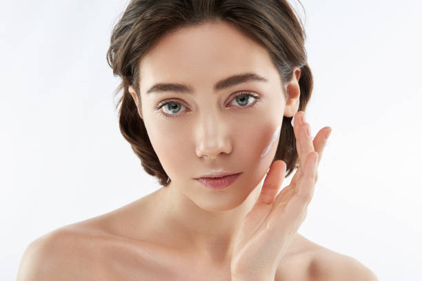 istock Calm sensual woman applying cream on face 1148893827