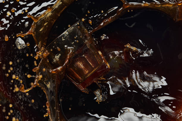 istock Overturned glass with black coffee, big splash and drops 1148895463