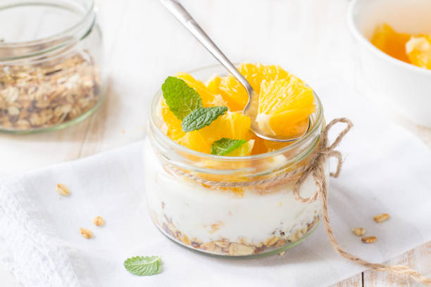 istock Yogurt, granola and orange in glass jar 1148895542