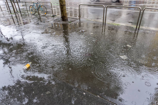 istock Raindrops in puddle on wet street 1148895587
