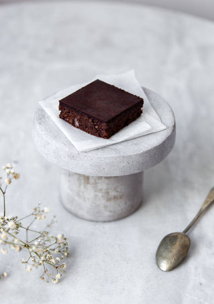 istock Vegan raw brownies with nuts and dates, on white marble background with copy space. Healthy dessert concept 1148897706