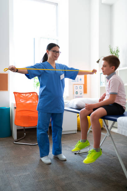 istock Professional dark-haired doctor in blue uniform showing needed exercises 1148899866