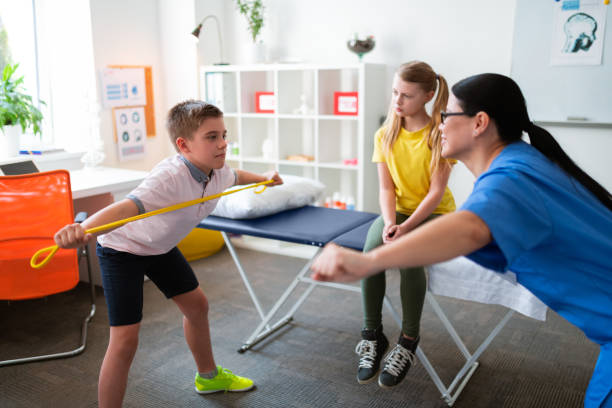 istock Professional therapist in blue uniform working with young kids 1148899886