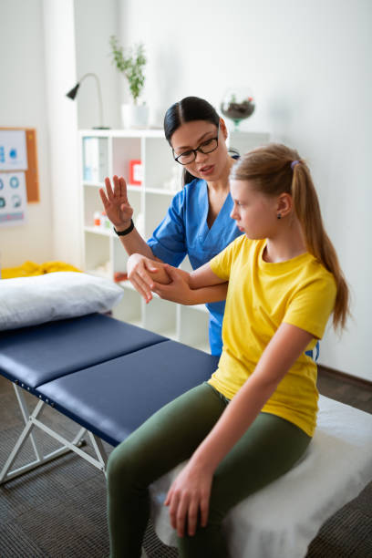 istock Active dark-haired nurse with long ponytail asking little girl 1148899971