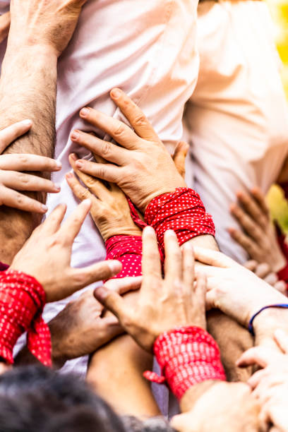 nahaufnahme der fügethände, die ein "kastell" bauen - castellers stock-fotos und bilder