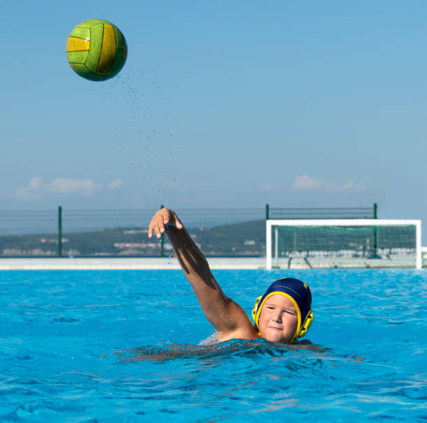 vue de face de jeune joueur de water-polo tirant au but - splashing color image front view head and shoulders photos et images de collection