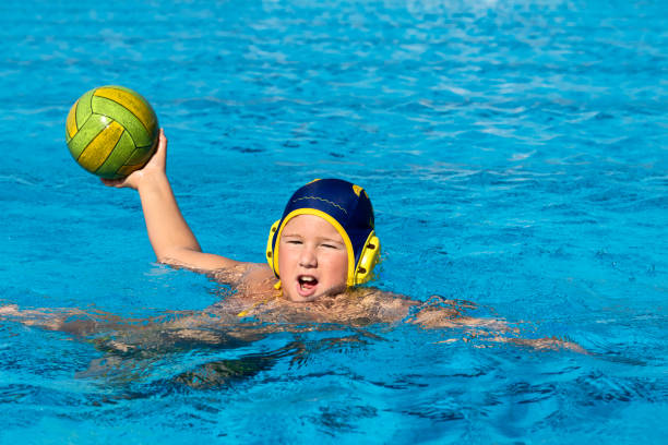 Front View of Young Water Polo Player Practicing Young water polo player with the ball practicing water polo stock pictures, royalty-free photos & images