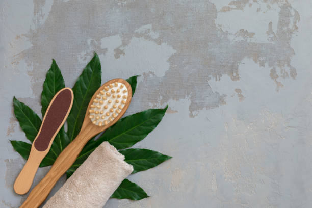 istock Body spa treatment bamboo brushes with bath towel on green tropical leaf background 1148902985