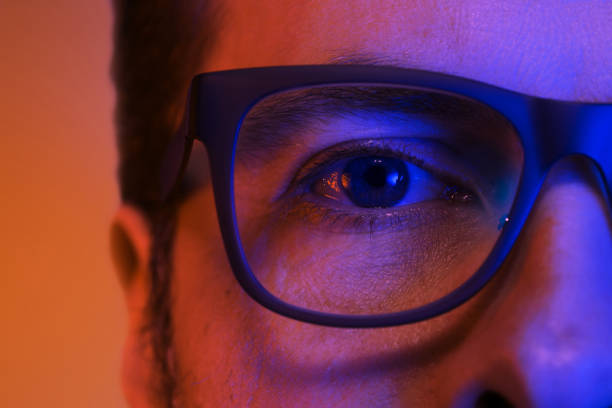 istock Eye and glasses - man's face close up (macro) in colorful light 1148903905