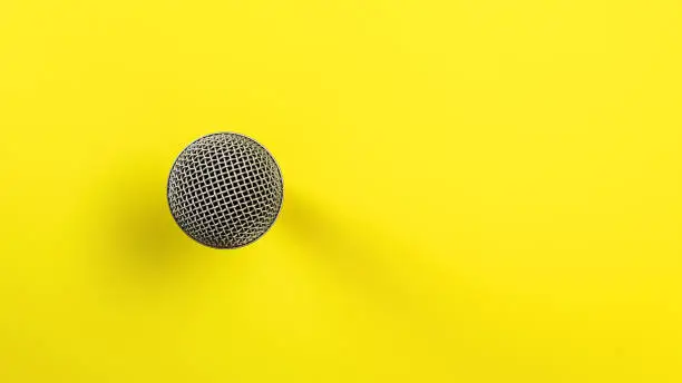 Photo of Microphone on yellow board, direct top down view, only ball with grid visible making so it looks abstract.
