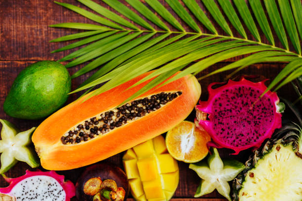 istock Tropical fruit on dark wooden background 1148904612