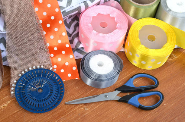 istock Color ribbons, scissors and pins set on wooden plank 1148906773