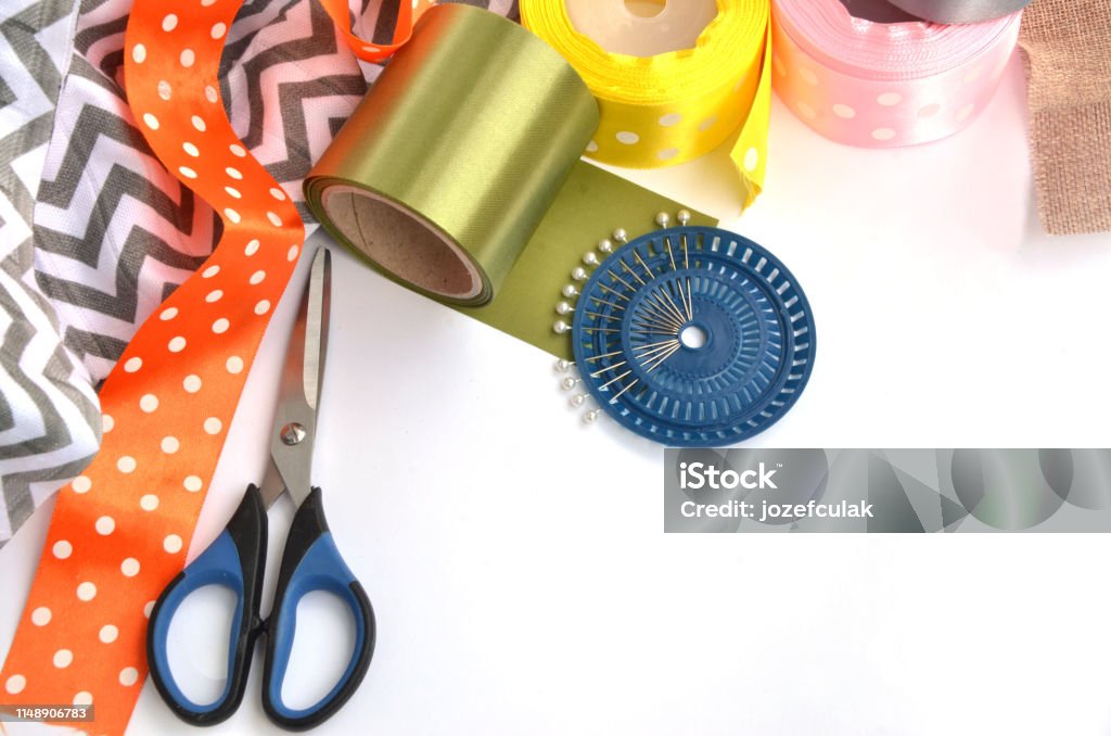 Flat lay made by color ribbons, scissors and pins on white background Ribbon - Sewing Item Stock Photo