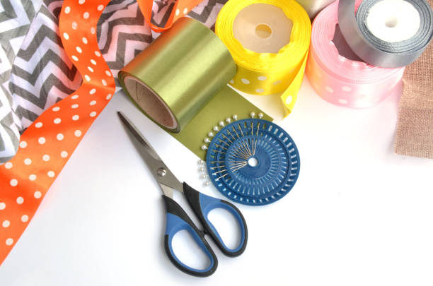 istock Flat lay made by color ribbons, scissors and pins on white background 1148906790
