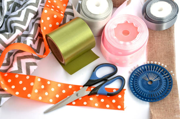 istock Flat lay made by color ribbons, scissors and pins on white background 1148906800