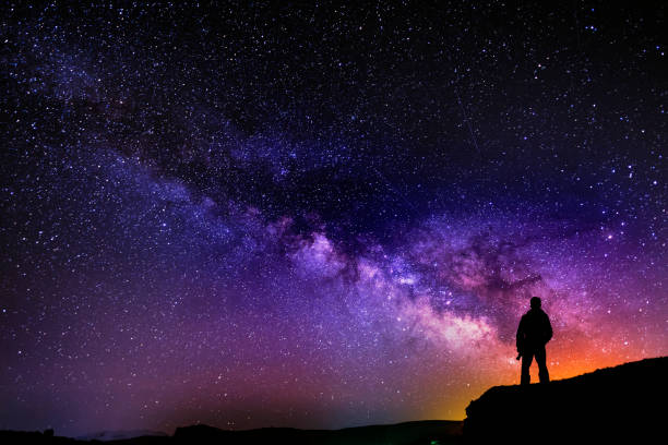 hermosa noche estrellada, silueta de hombre con una cámara mirando la galaxia de la vía láctea. - astronomía fotos fotografías e imágenes de stock