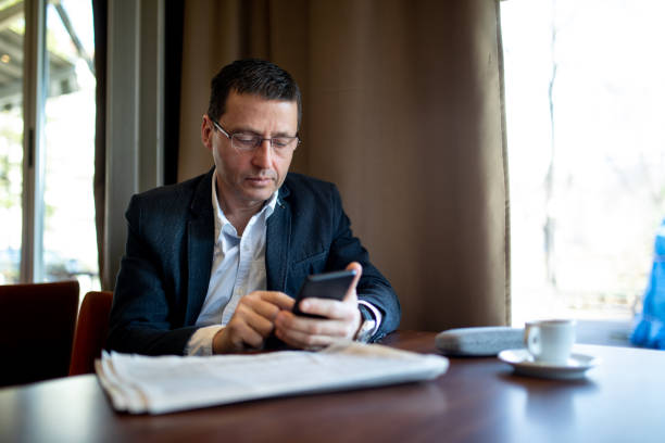 istock Serious senior businessman texting at a cafe while enjoying a coffee break 1148909832