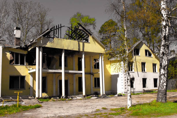 сгорел после пожара большой загородный дом с рухнувшей поврежденной крышей на фоне серого неба. сгорел большой загородный дом с рухнувшей � - house farm brick chimney стоковые фото и изображения