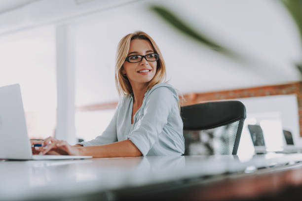 istock Cheerful woman smiling and looking away while working 1148917360