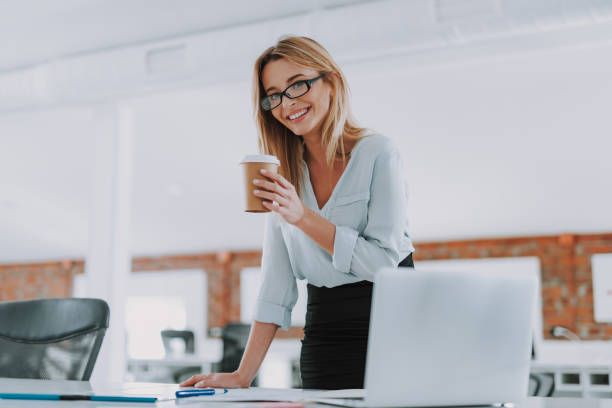 istock Young entrepreneur with coffee standing and smiling 1148917415